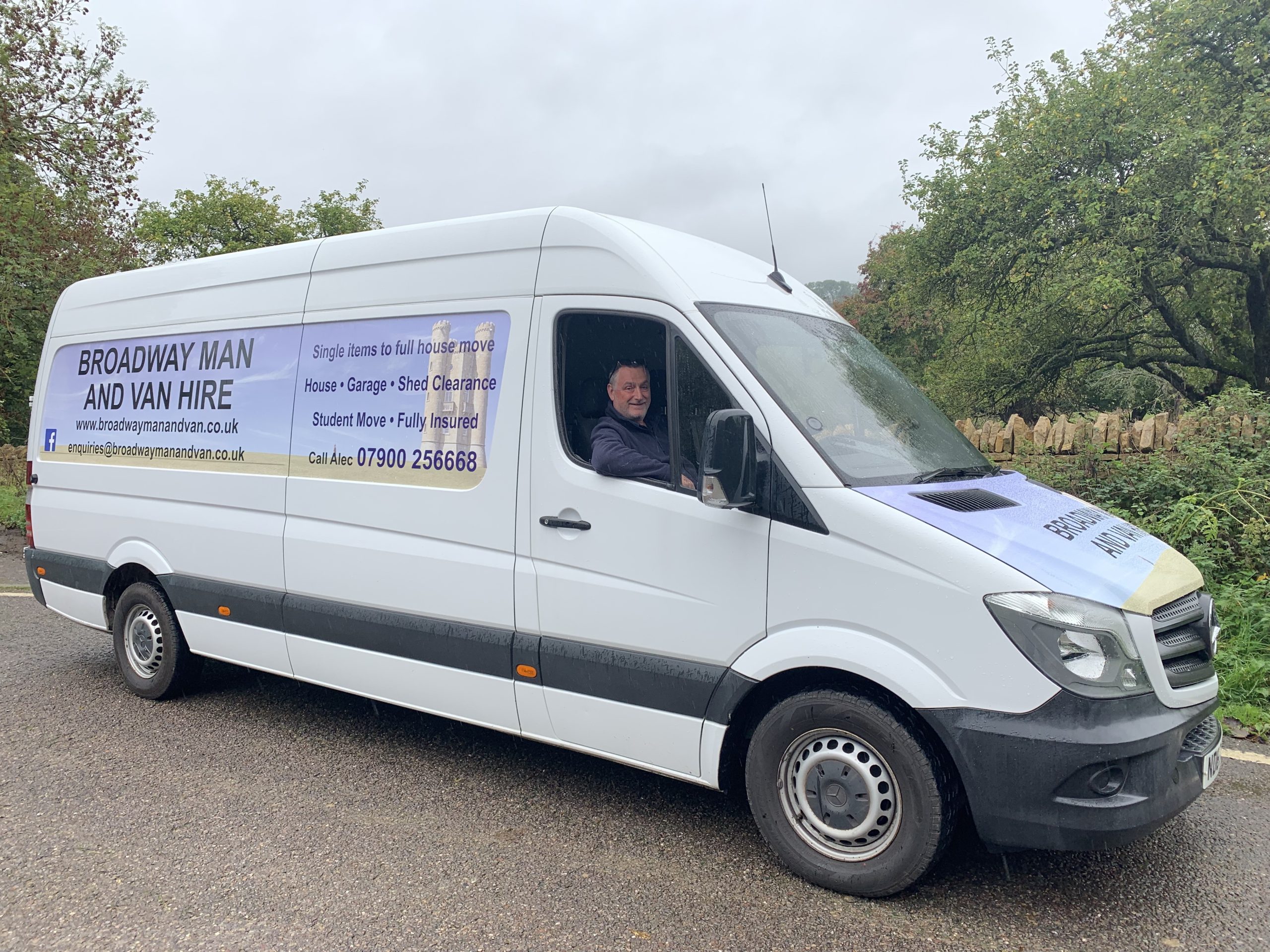 right front side of the big white van with Alec sat in the drivers seat